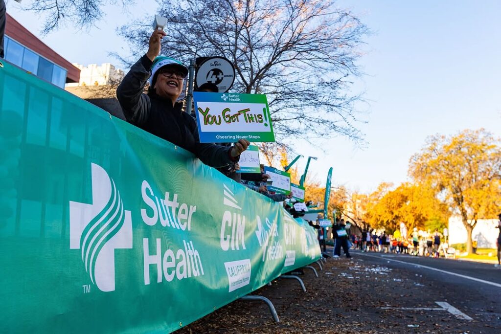 People cheering on the side at Sutter Heatlh CIM marathon
