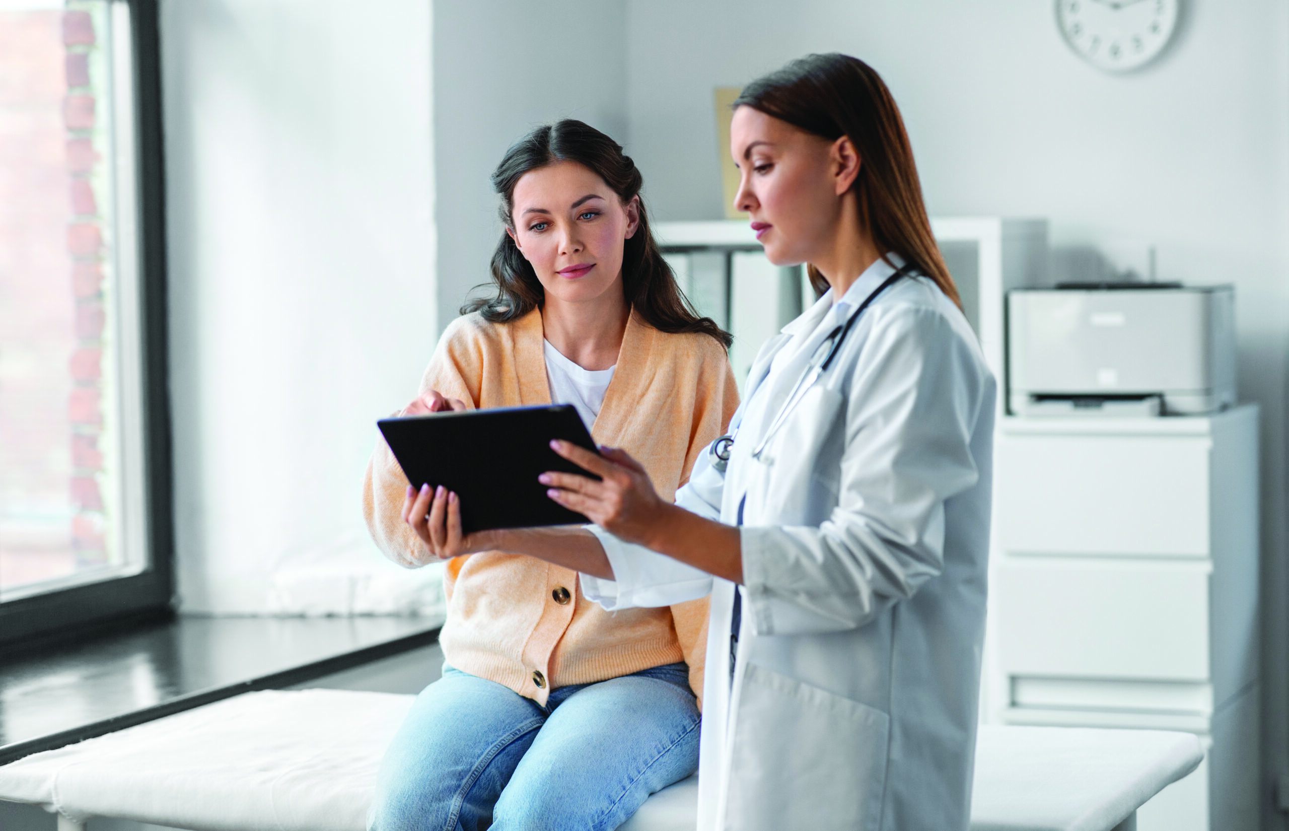 female doctor with tablet pc and woman at hospital