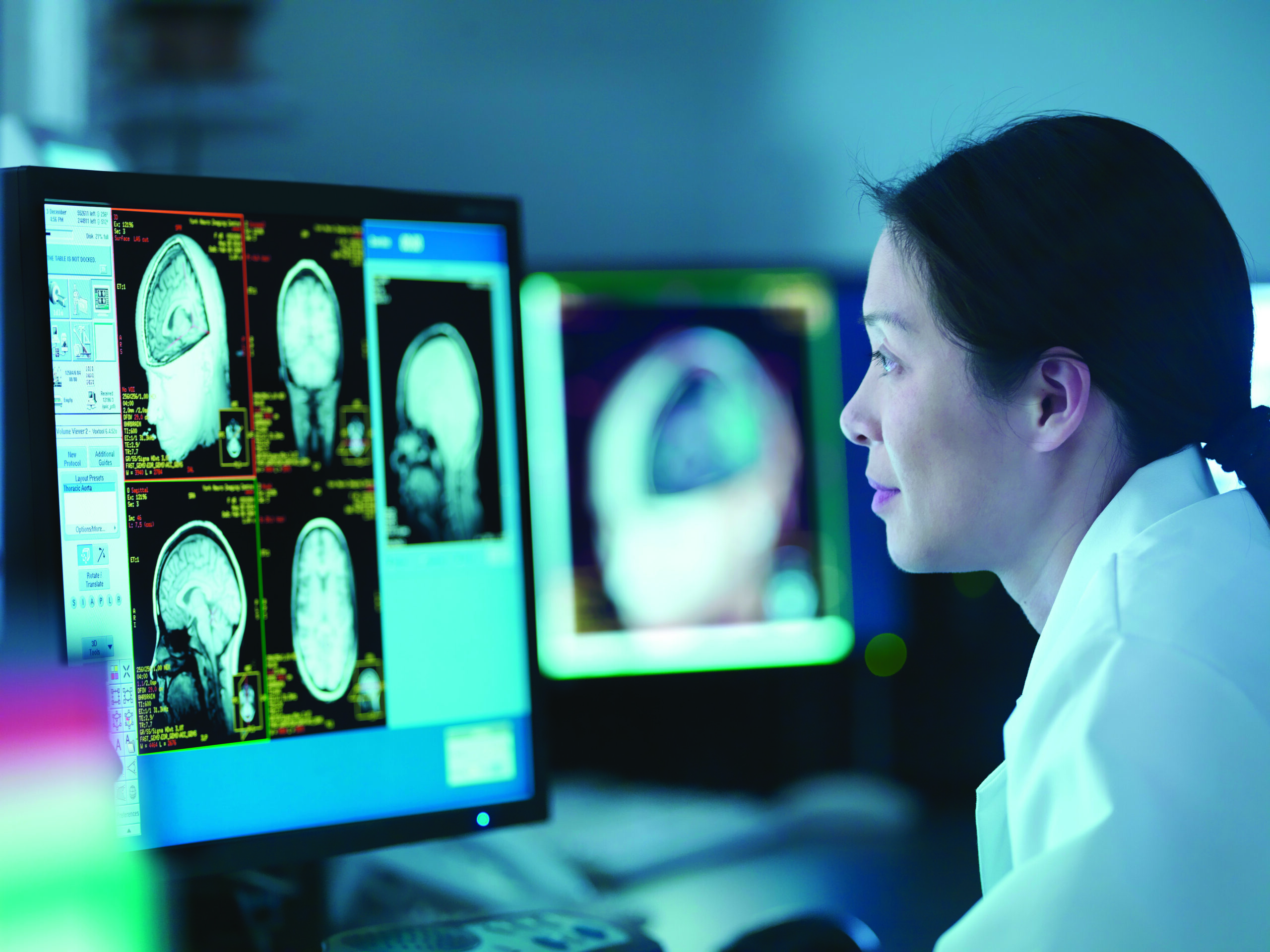 Scientist looking at 3D rendered graphic scans from Magnetic Resonance Imaging (MRI) scanner, close up